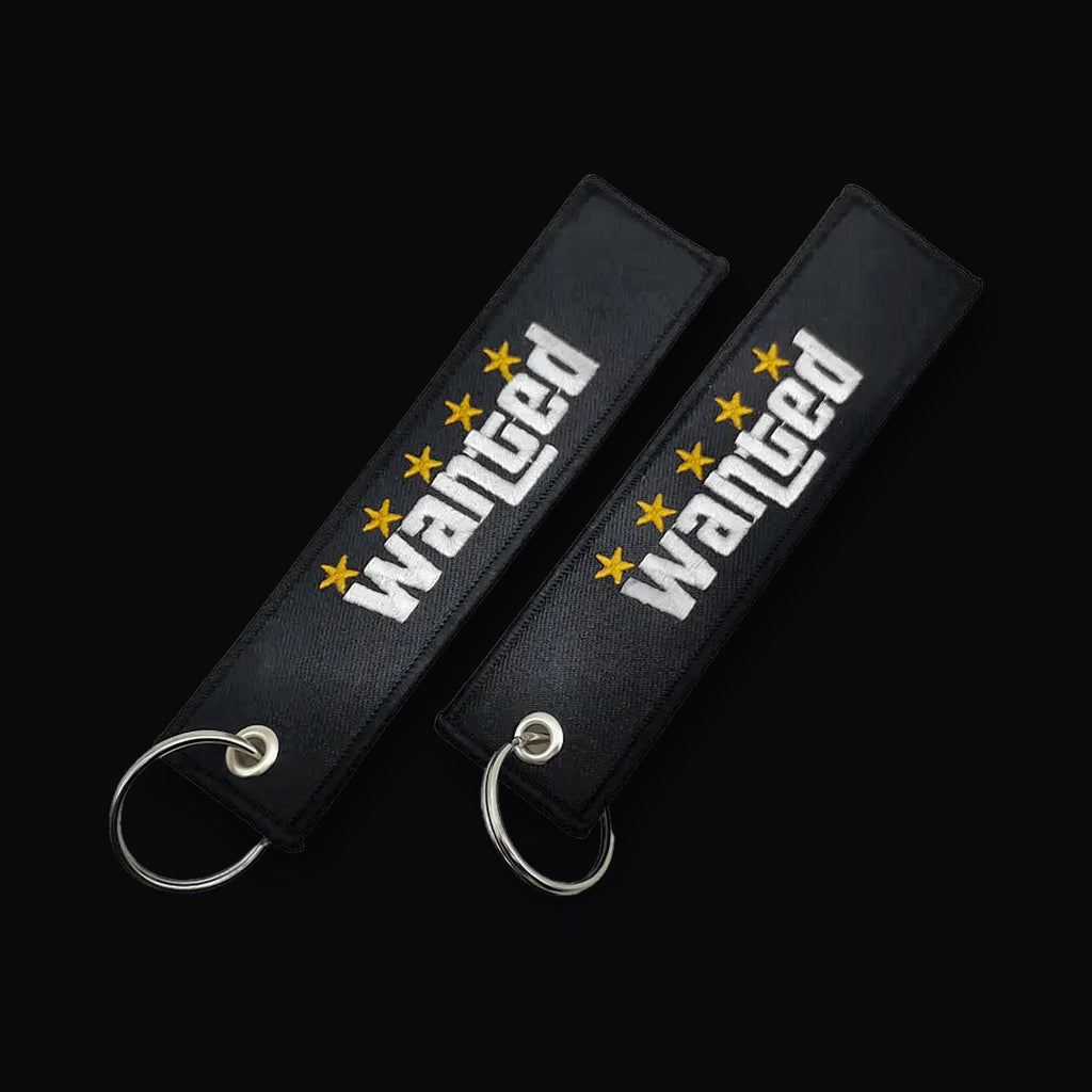 Two views of the Wanted Keytag showing both stitched sides