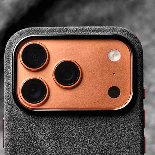 Genuine Italian Alcantara case in black with metal camera ring on an orange iPhone 17 Pro